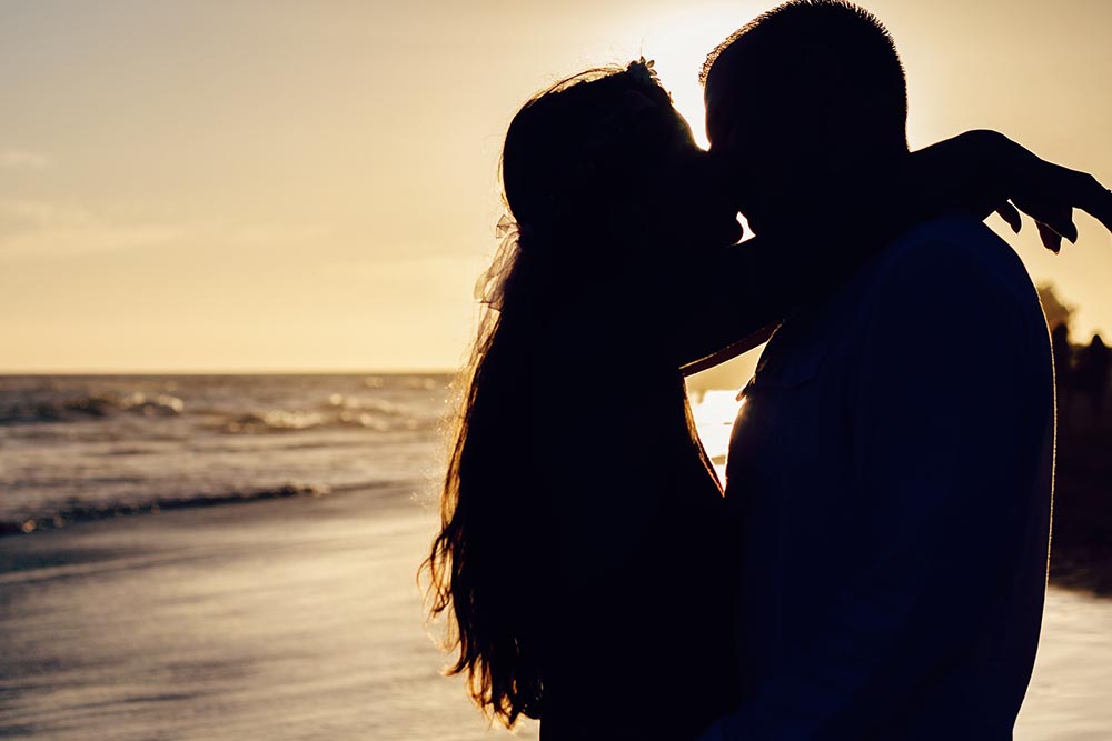 Couple kissing on romantic beach to represent rules of seduction