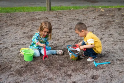 Children playing in a sand box.