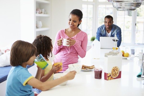 Family Having Breakfast In Kitchen Together